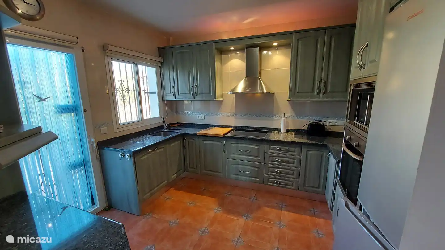 Die komplette Küche mit separatem Zugang zur seitlichen Terrasse