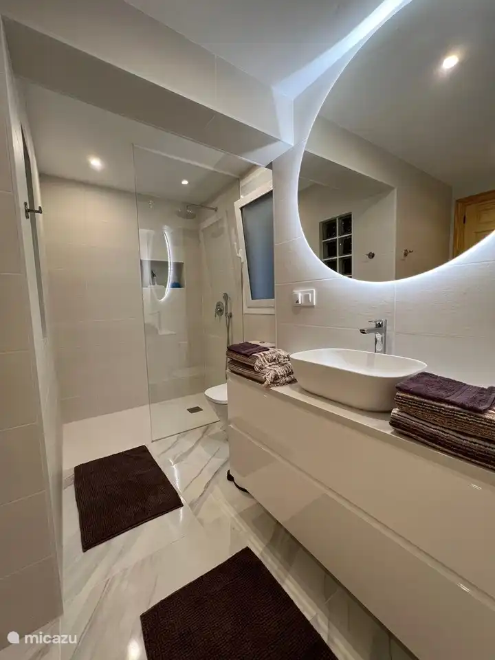 Ensuite bathroom belonging to bedroom 4 with shower, toilet and spacious sink unit and towel rack.
