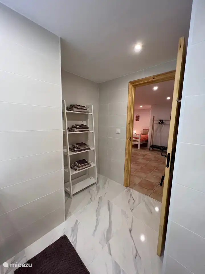 Ensuite bathroom belonging to bedroom 4 with shower, toilet and spacious sink unit and towel rack.