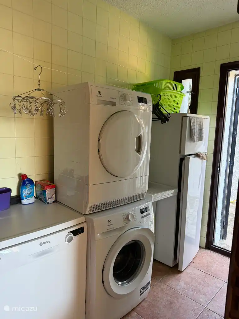 De bijkeuken met wasmachine, wasdroger en vaatwasser én extra koelkast