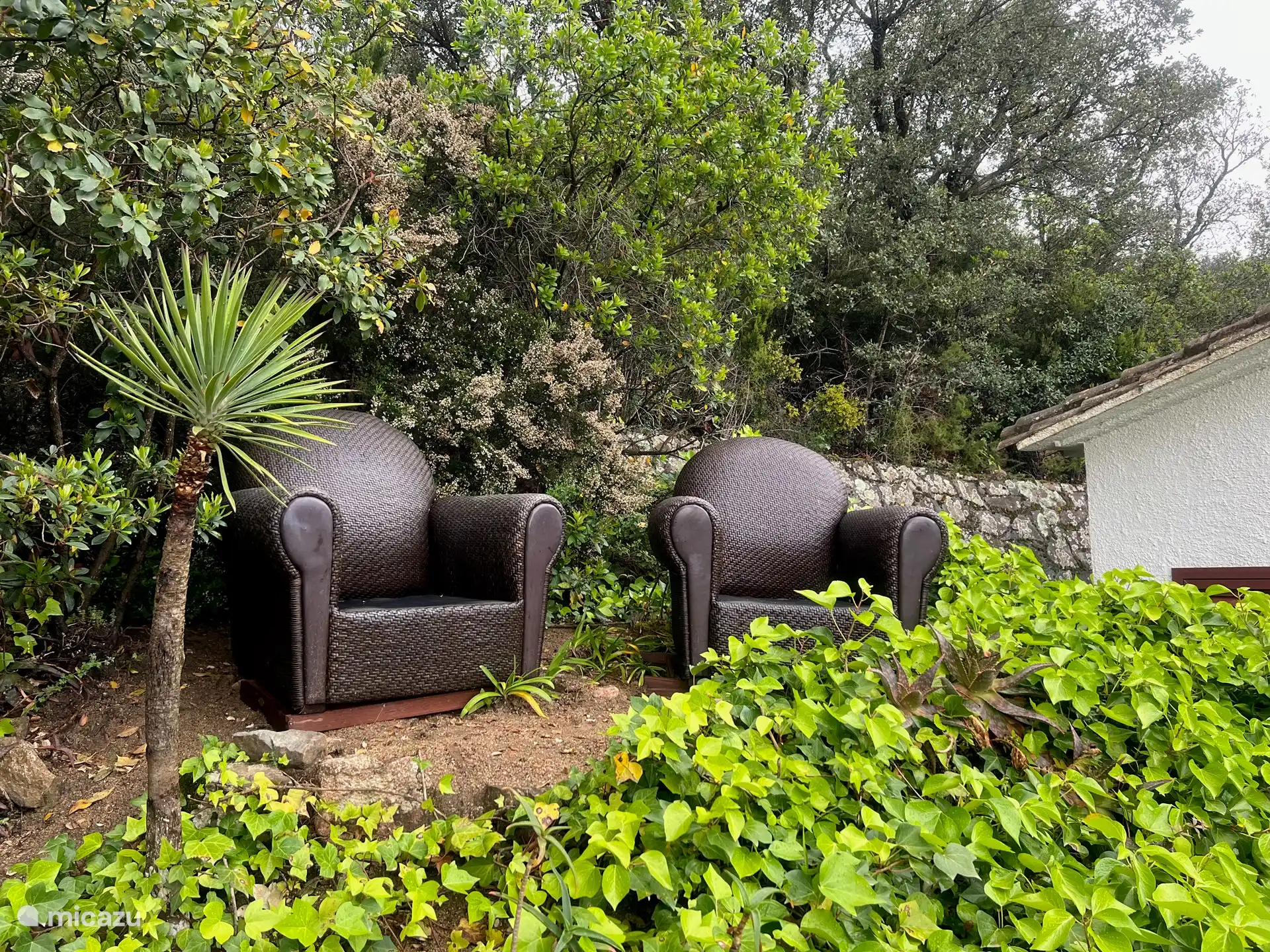 Herrliches Sitzen auf einer Terrasse in der Natur. Kissen dieser Stühle liegen auf der Veranda