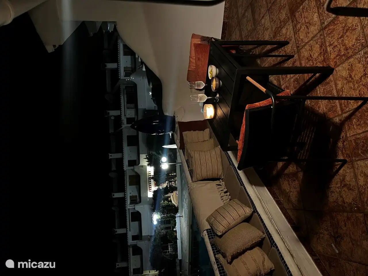 Balcón con banco y mesa con sillas