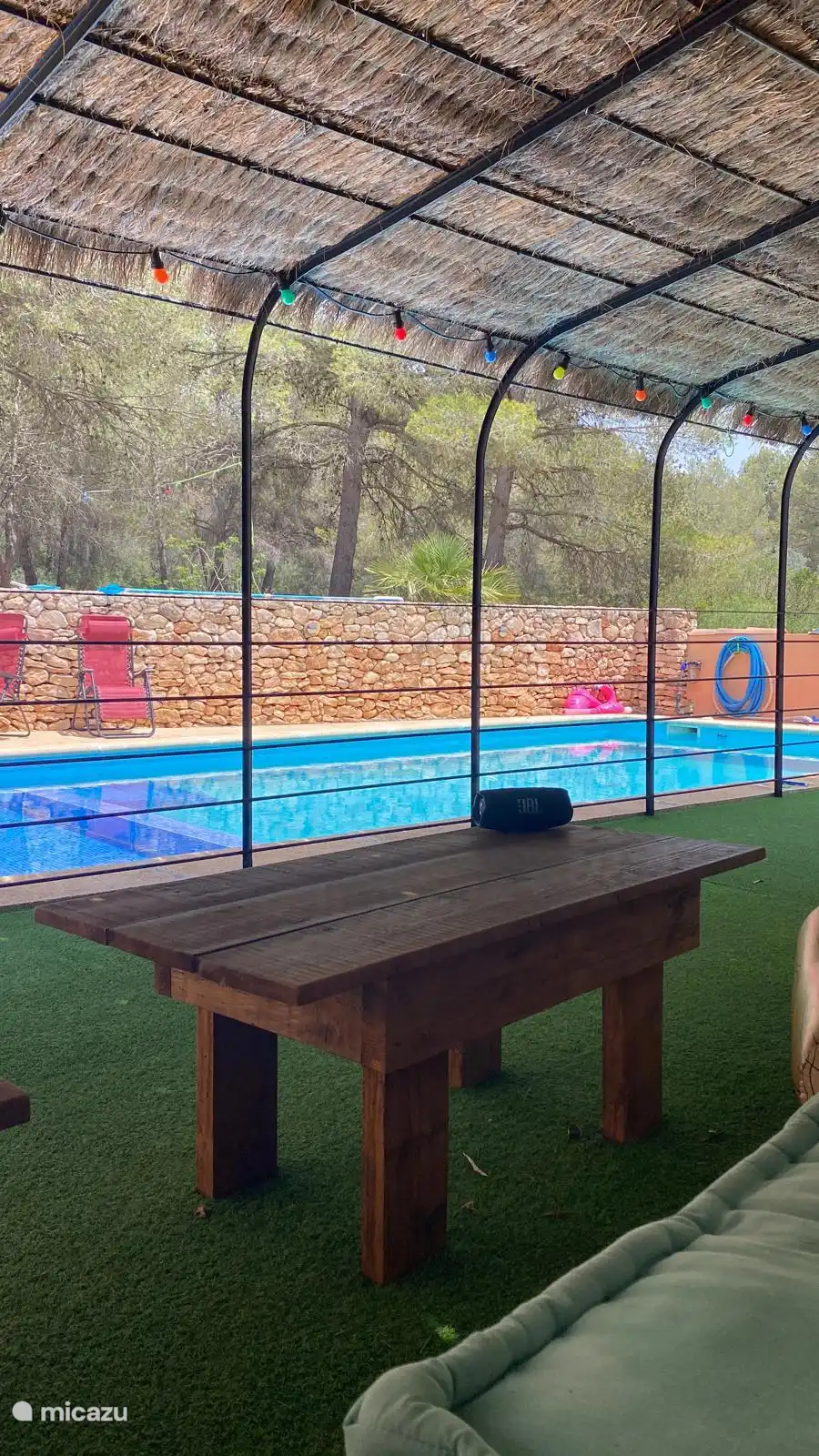 Bij het zwembad is een overdekte ruimte om lekker te chillen. Dit is een gedeelde ruimte, alle gasten inclusief de bewoners kunnen hier gebruik van maken