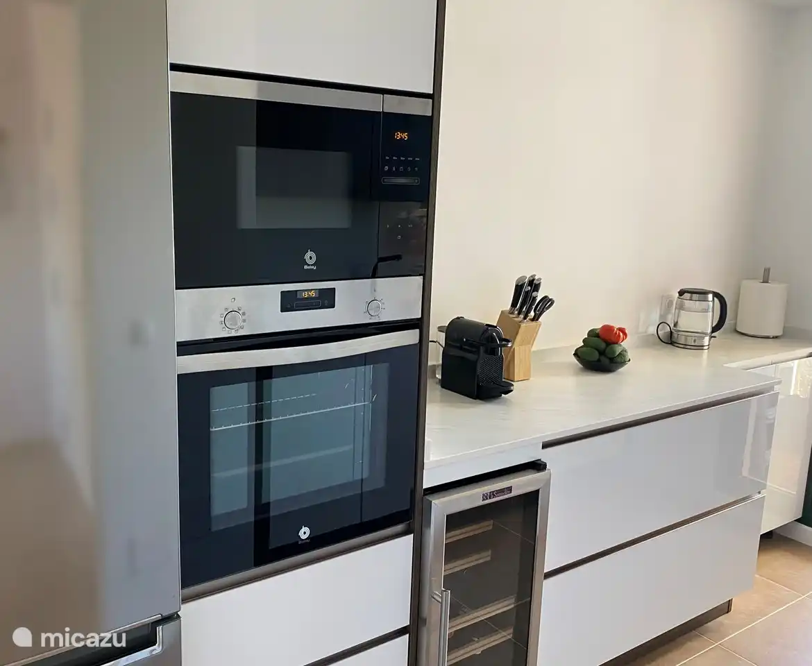 Cuisine avec grand réfrigérateur-congélateur, four, micro-ondes et réfrigérateur à vin