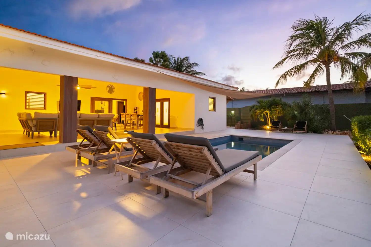 Kas Sinku - Sunrentals Bonaire swimming pool, sunbeds and covered terrace at dusk