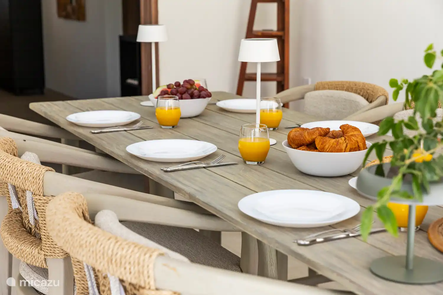 Kas Sinku - Sunrentals Bonaire dining table set with croissants, grapes and fresh orange juice