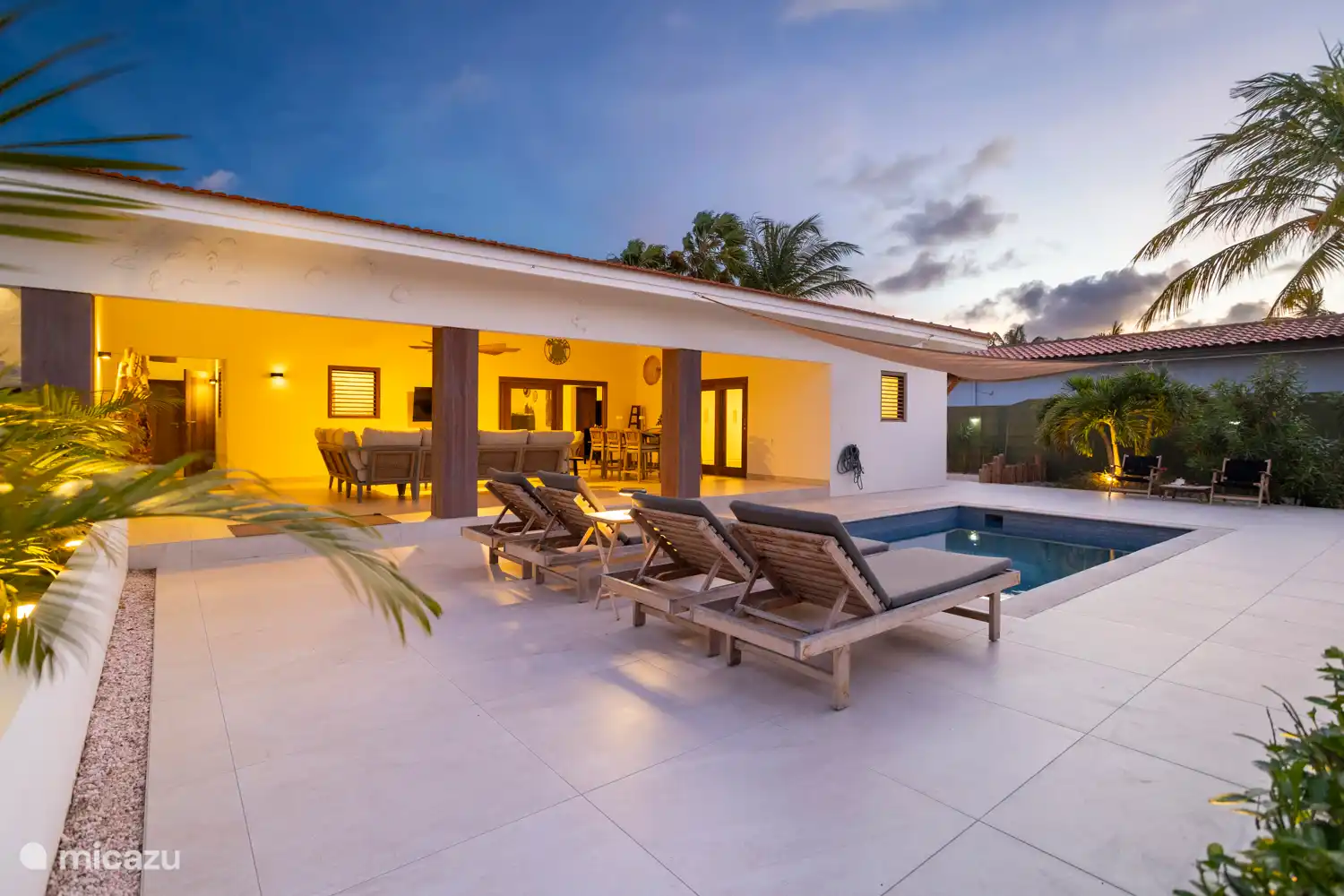 Kas Sinku - Sunrentals Bonaire pool deck with sunbeds and covered terrace at sunset