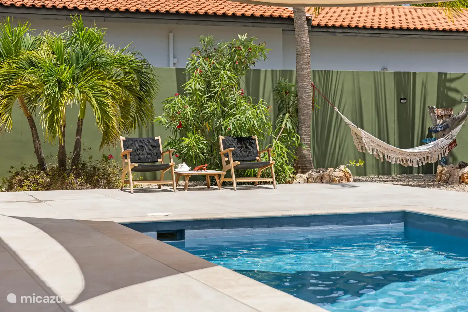 Kas Sinku - Sunrentals Bonaire chairs by pool and hammock