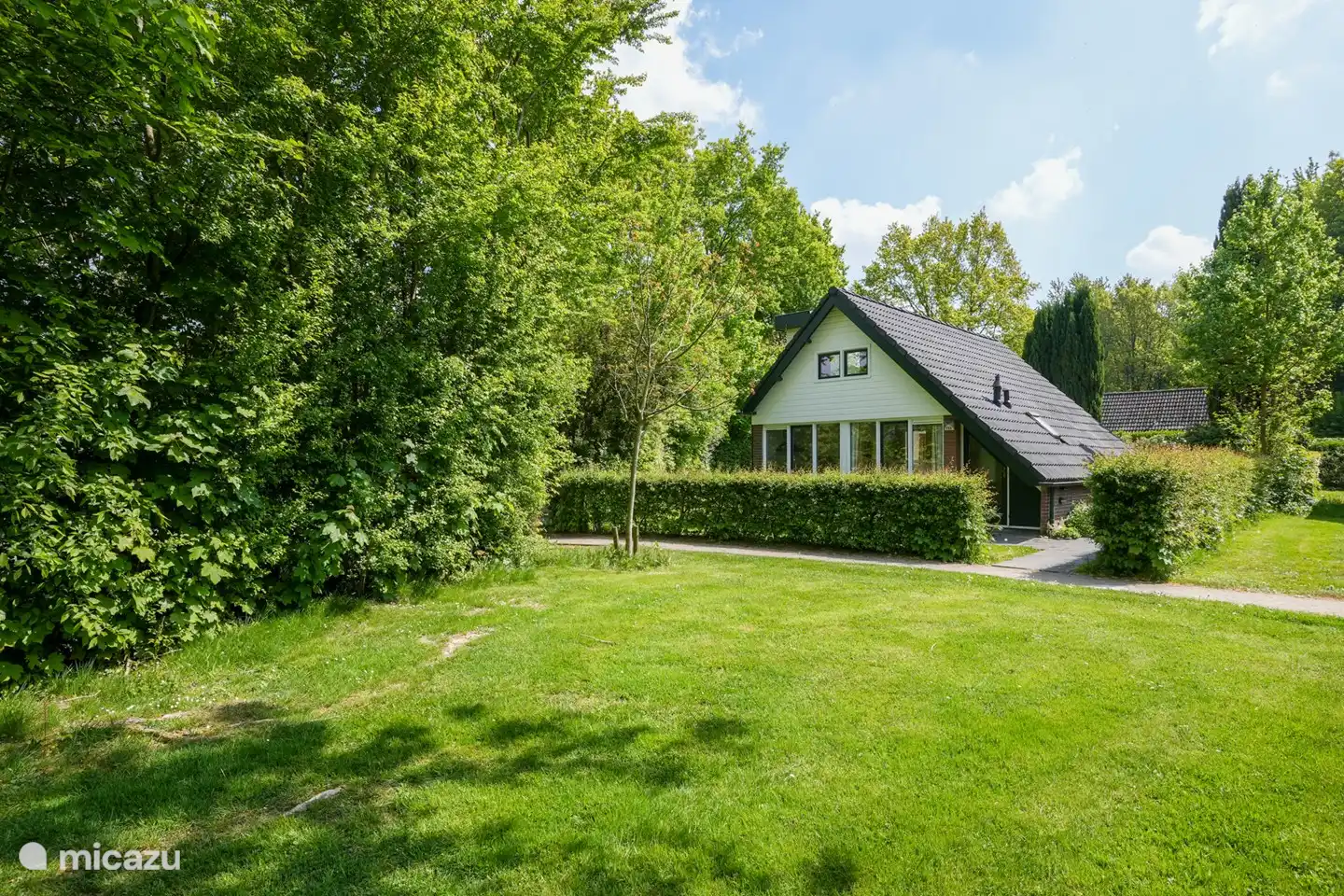 Vooraanzicht, met mooie meidoornhaag en geheel omzoomd hekwerk 