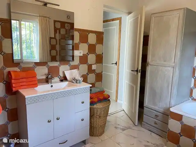 Zweites Badezimmer mit Badewanne, WC und Waschbecken.