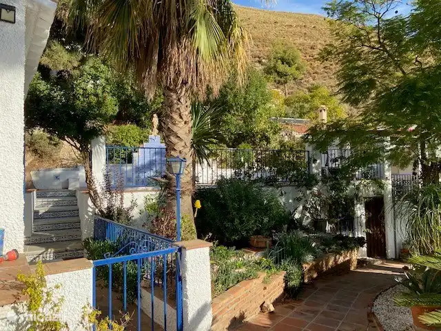 Der blumige Garten bietet Zugang zum Pool, der aus Sicherheitsgründen durch ein Tor verschlossen ist. Die separate Terrasse auf der rechten Seite verfügt über eine Außenküche, in der Sie einen Aperitif genießen können.