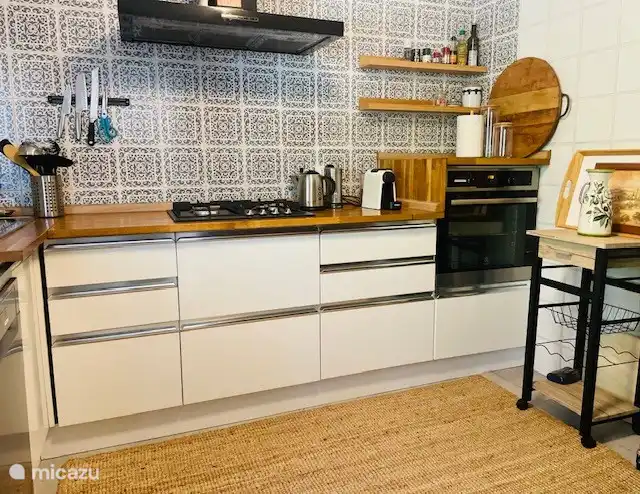 Voll ausgestattete Küche neben dem Wohnzimmer mit Backofen und Geschirrspüler  