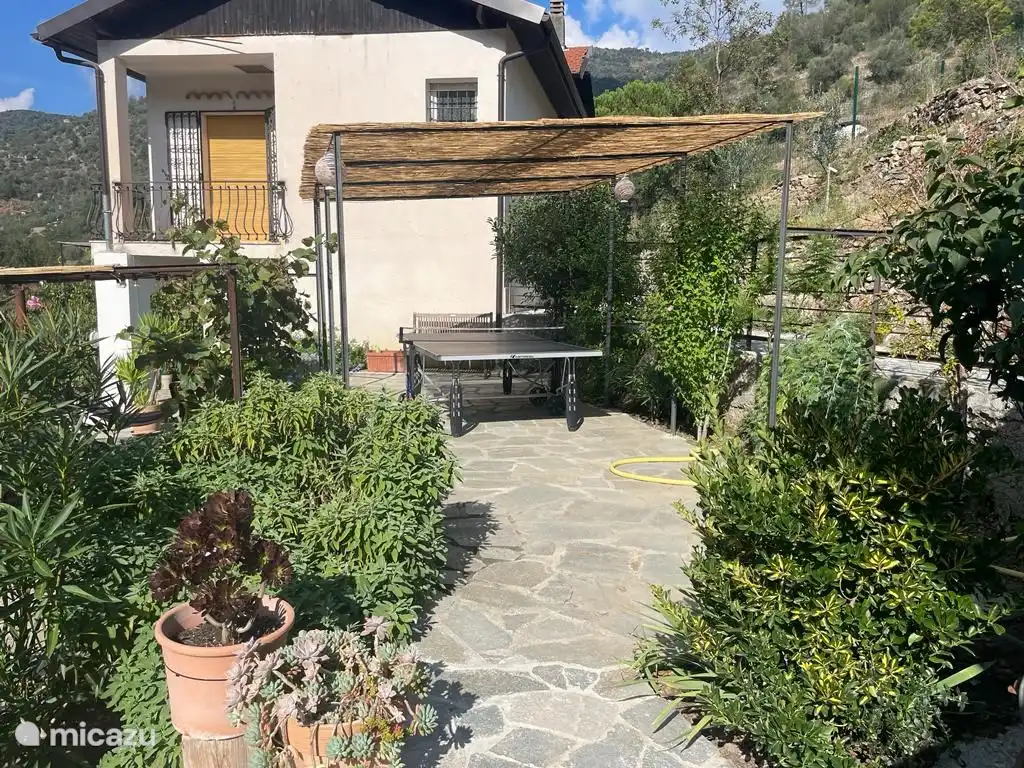 Tischtennisplatte auf der Terrasse neben dem Haus.