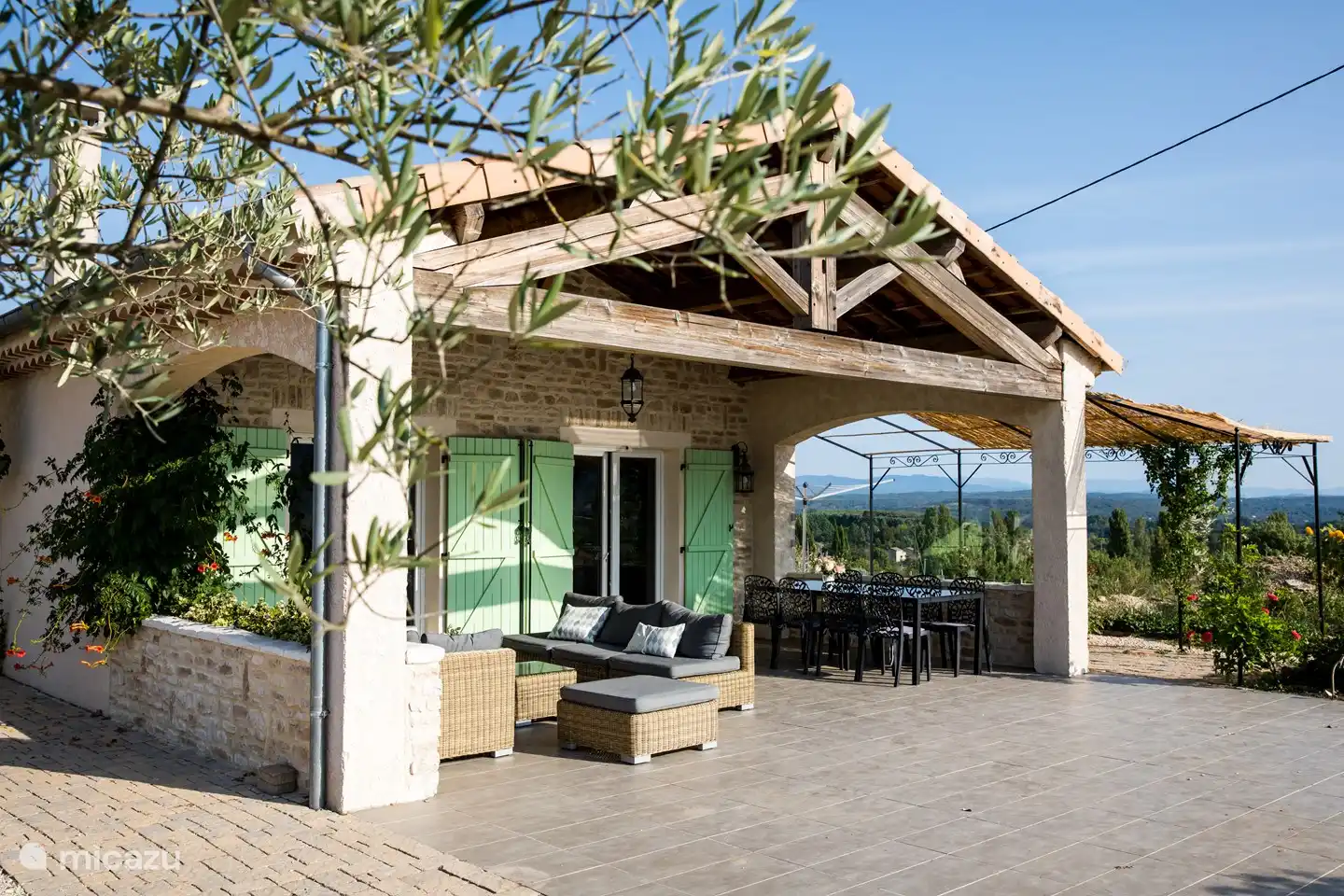 Terrasse avec salon et table à manger avec 8 chaises.