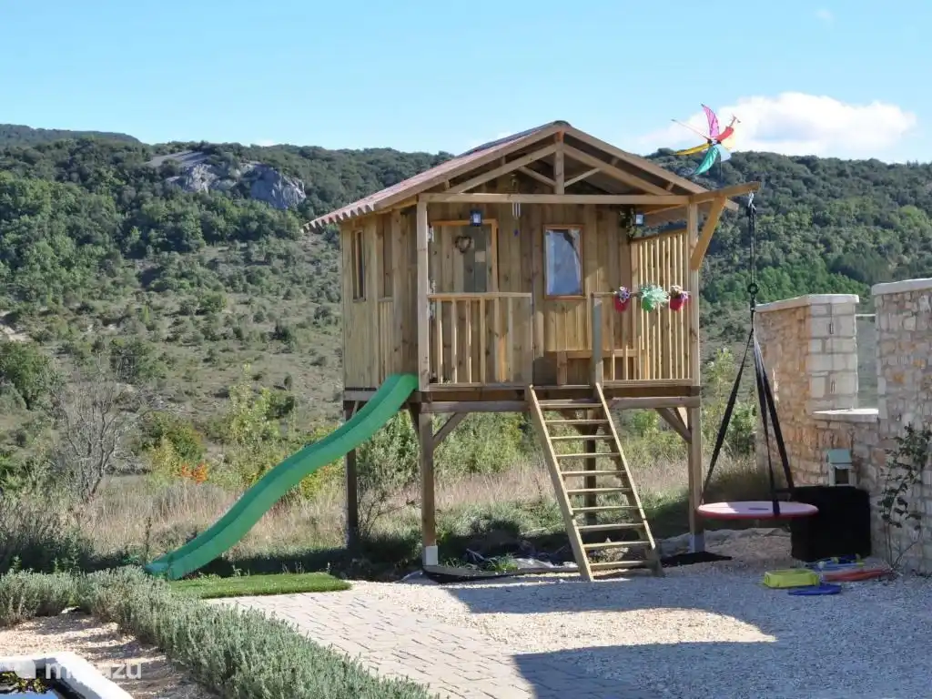 Maisonnette avec balançoire et toboggan.