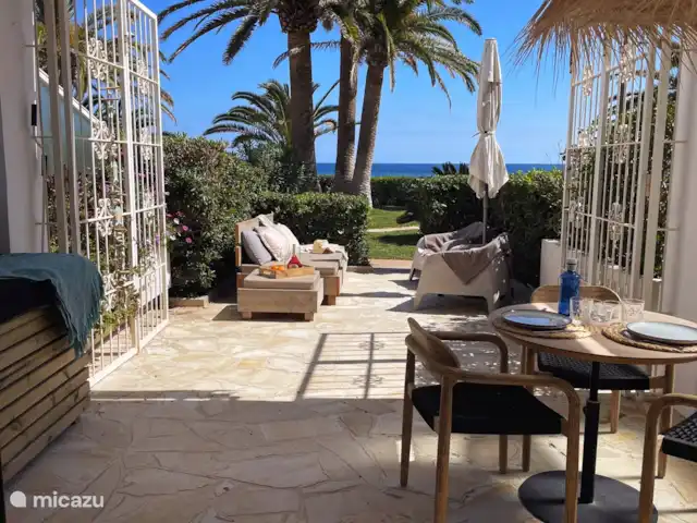 Casa Zita Playa | Espagne, Ibiza, Santa Eulalia - appartement La terrasse dispose d’un salon, d’un canapé, d’un parasol, de stores extensibles, d’un canapé/chaise longue dans le patio et d’une table extérieure avec des chaises.