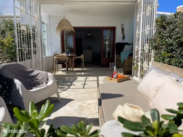 Casa Zita Playa | Espagne, Ibiza, Santa Eulalia - appartement La terrasse dispose d’un salon, d’un canapé, d’un parasol, de stores extensibles, d’un canapé/chaise longue dans le patio et d’une table extérieure avec des chaises.
