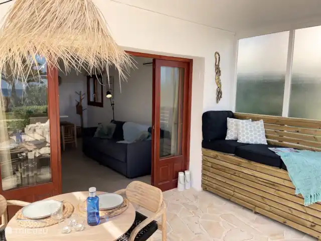 Casa Zita Playa | Espagne, Ibiza, Santa Eulalia - appartement La terrasse dispose d’un salon, d’un canapé, d’un parasol, de stores extensibles, d’un canapé/chaise longue dans le patio et d’une table extérieure avec des chaises.
