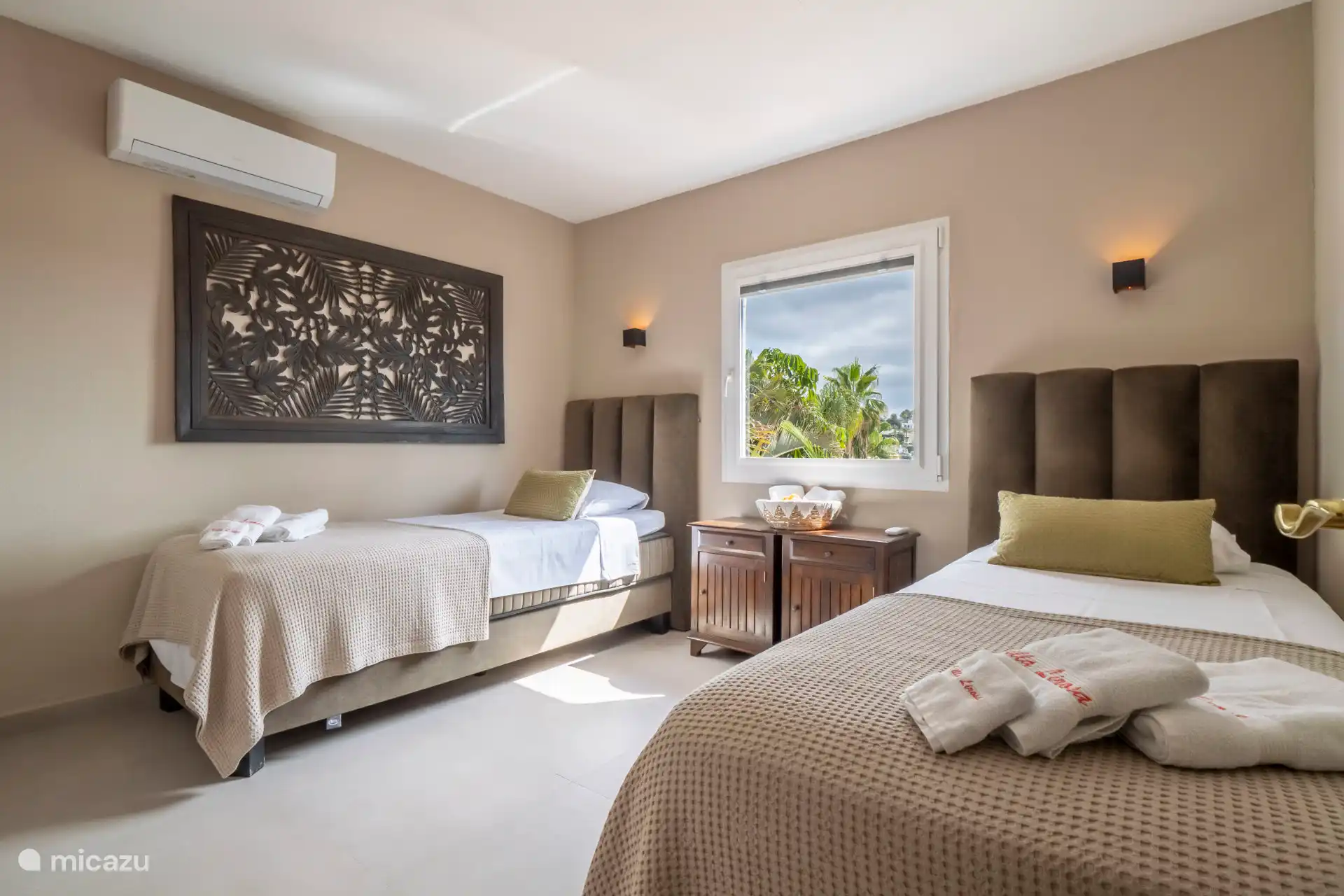 Schlafzimmer mit zwei Einzelbetten und Blick auf den Pool