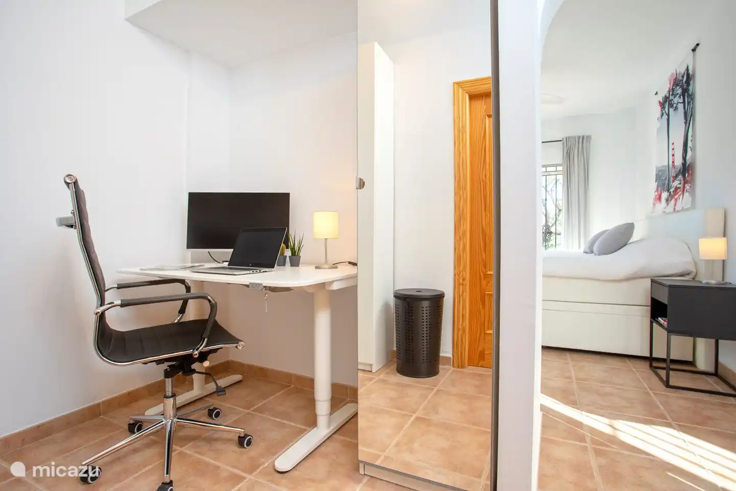 Arbeitsplatz für 2 Personen mit zwei Sitz-/Stehtischen und 1 großem Monitor.