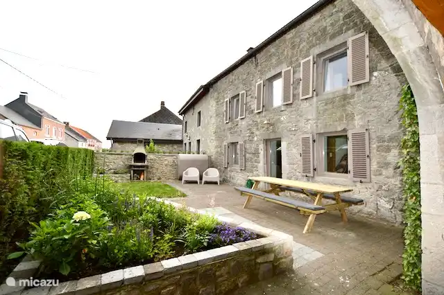 eingezäunter Garten mit Grill und Sitzmöbeln