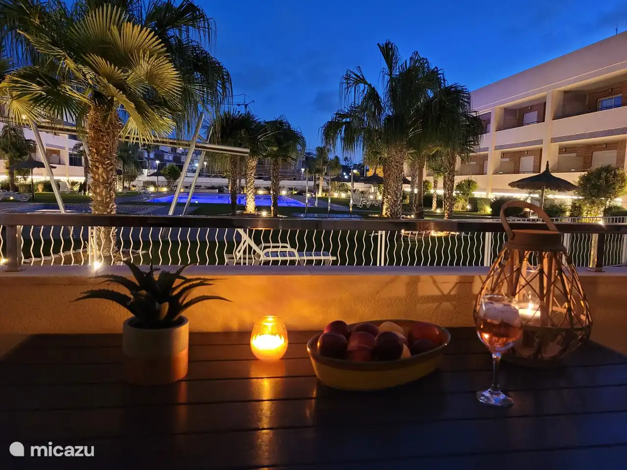 Blick vom Balkon auf den wunderschön beleuchteten Innenhof mit Swimmingpool