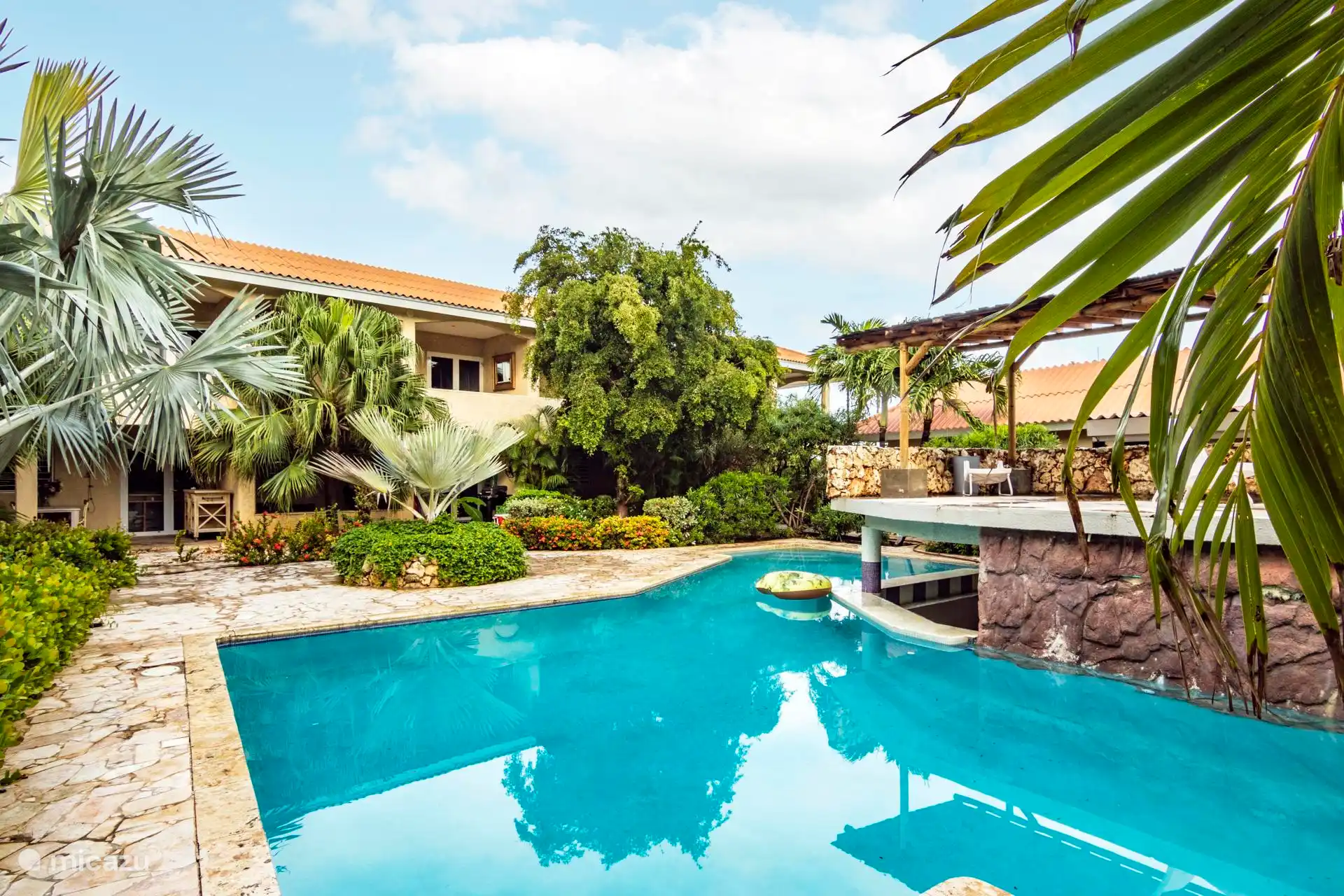 La hermosa piscina con tumbonas 