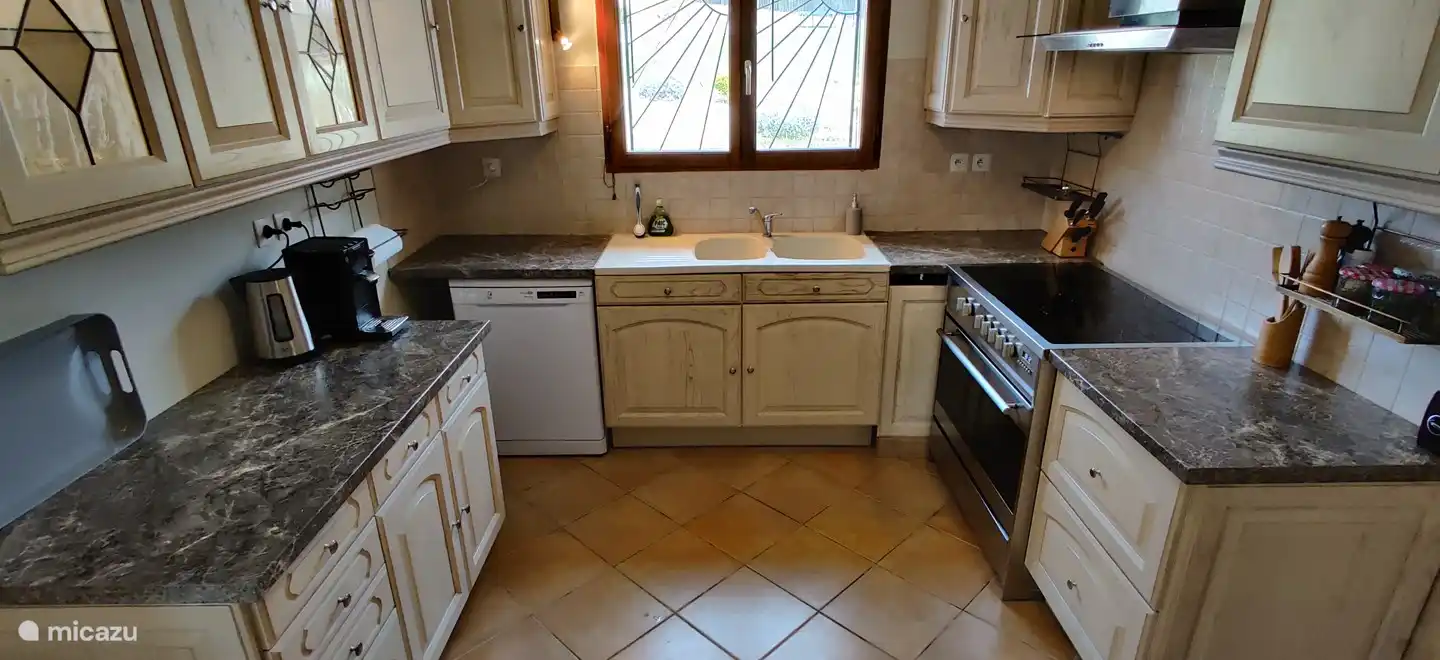 The attractive, spacious kitchen in French style is fully equipped.
