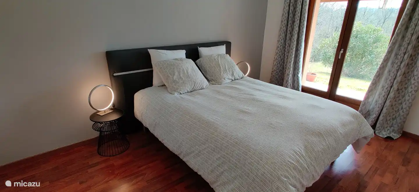 One of the spacious bedrooms, with a wonderful bed and patio doors to the garden.