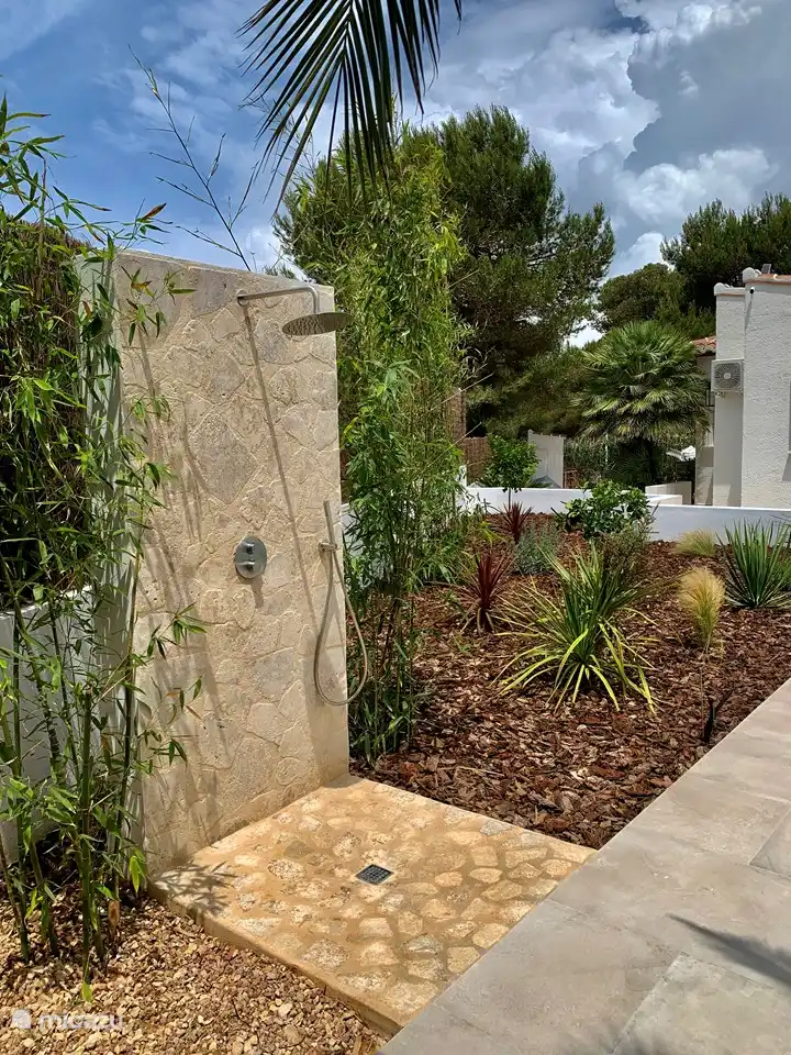 La douche extérieure (avec eau chaude et froide, douche à effet pluie et douchette) est merveilleusement cachée entre les bambous et constitue un bel ajout à la piscine.