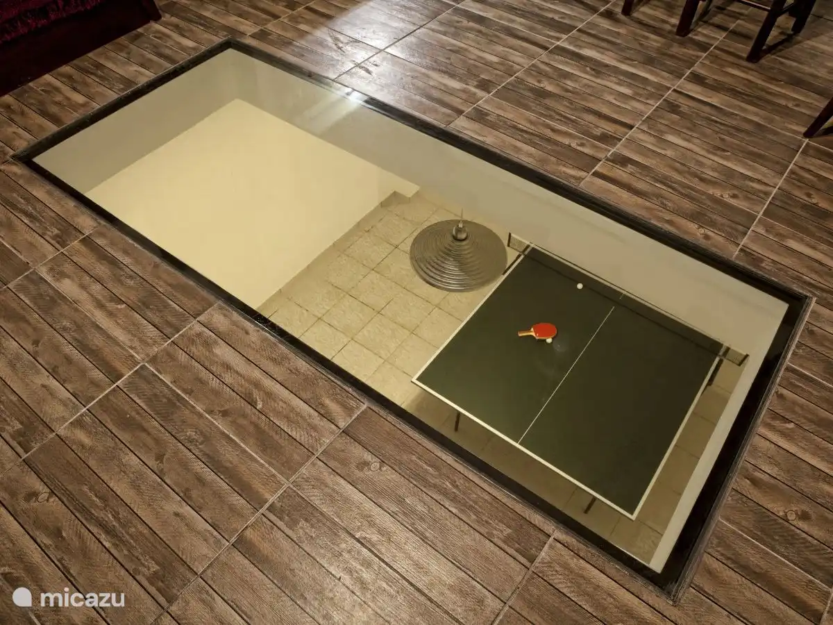 Zicht vanuit de woonkamer door de glazen vloer de speelkamer in