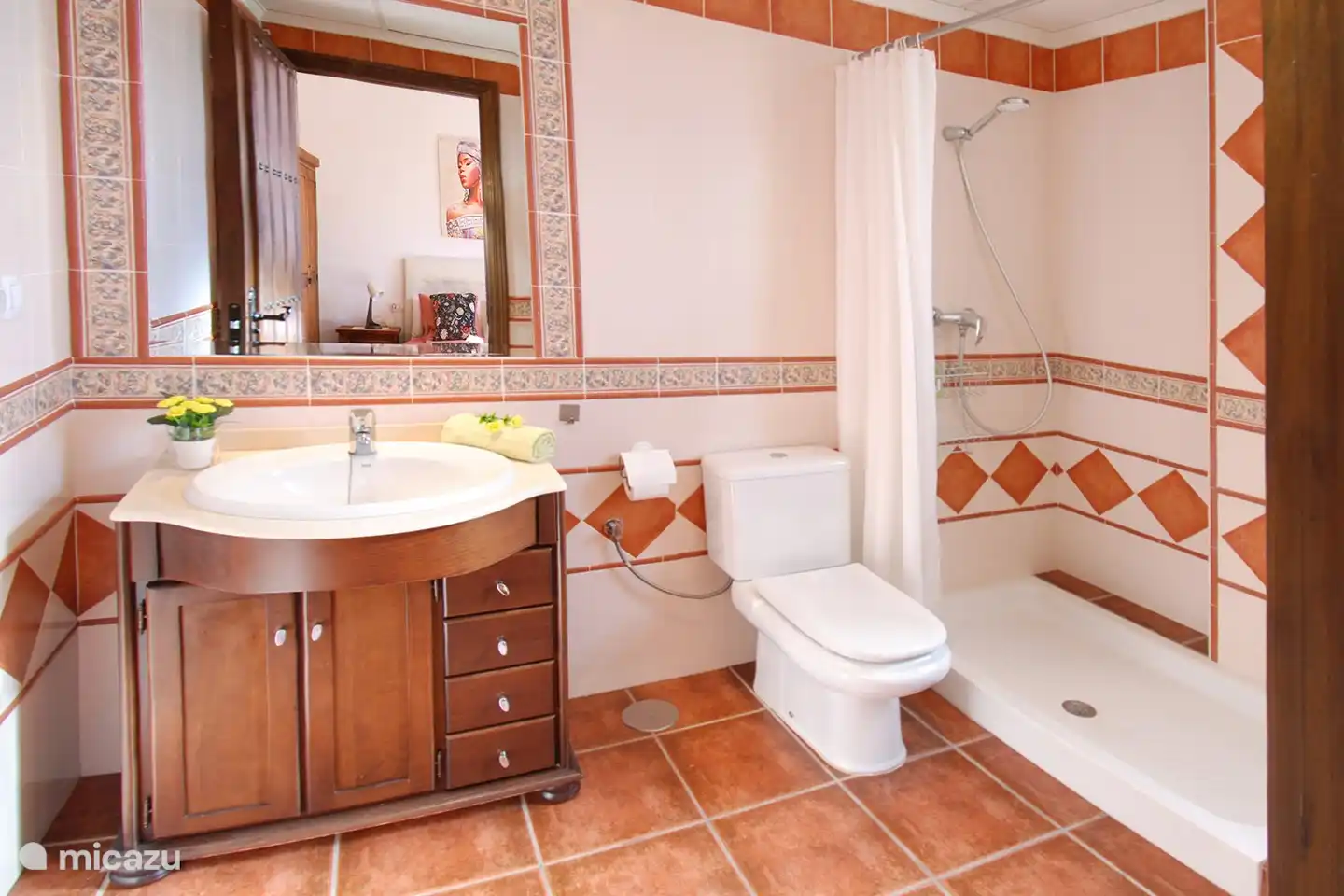De en-suite badkamer met ruime inloopdouche en toilet. 