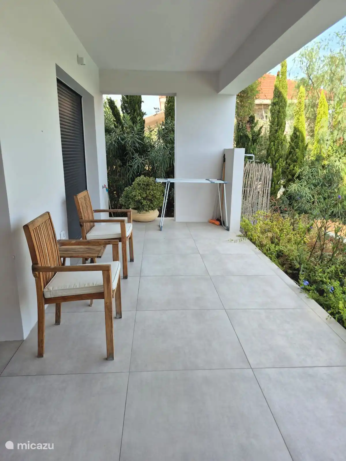 Terras voor slaapkamers beneden aan tuin en zwembad