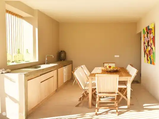 Un regard sur la cuisine extérieure avec barbecue et réfrigérateur et table à manger spacieuse avec style