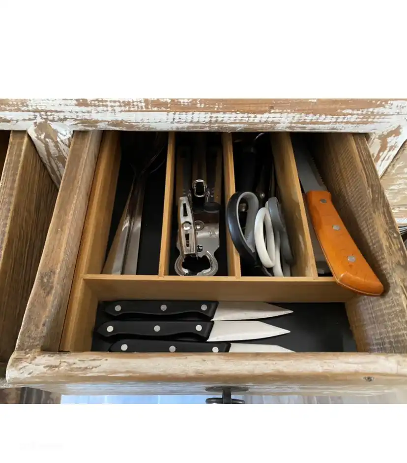 Bread knife, potato peelers, cheese slicer, opening, scissors, pizza cutter, serving spoons in the drawer of the sideboard.