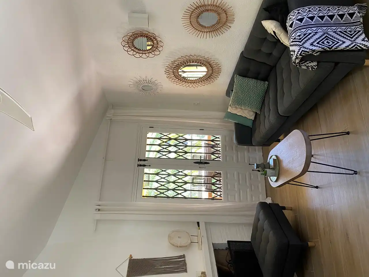 The patio doors to the balcony. With a view of the cozy balcony and the beautiful palm tree.