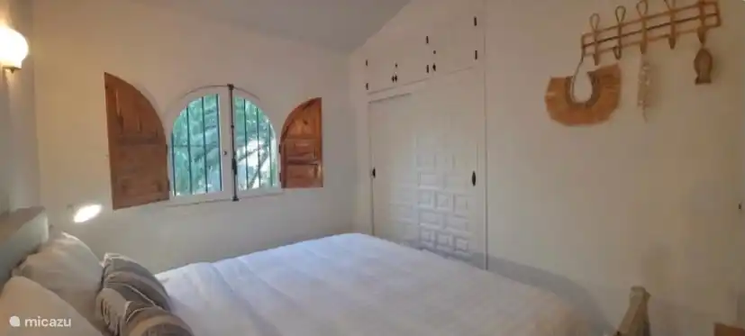 Large built-in wardrobe with shelves and rod with many clothes hangers. Both bedrooms have French windows with mosquito nets.