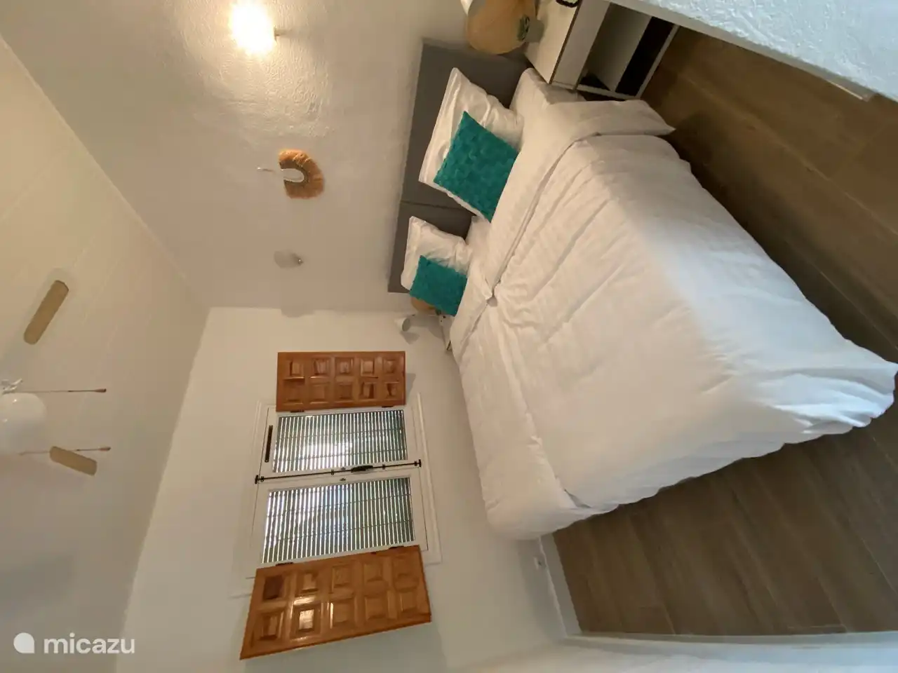 The 2nd bedroom with 2 1-person box springs with topper of 90x200 with bedside tables with night lamps with USB charging point. The windows can be opened and have mosquito nets. A wooden slatted roller blind hangs on the outside of the window.