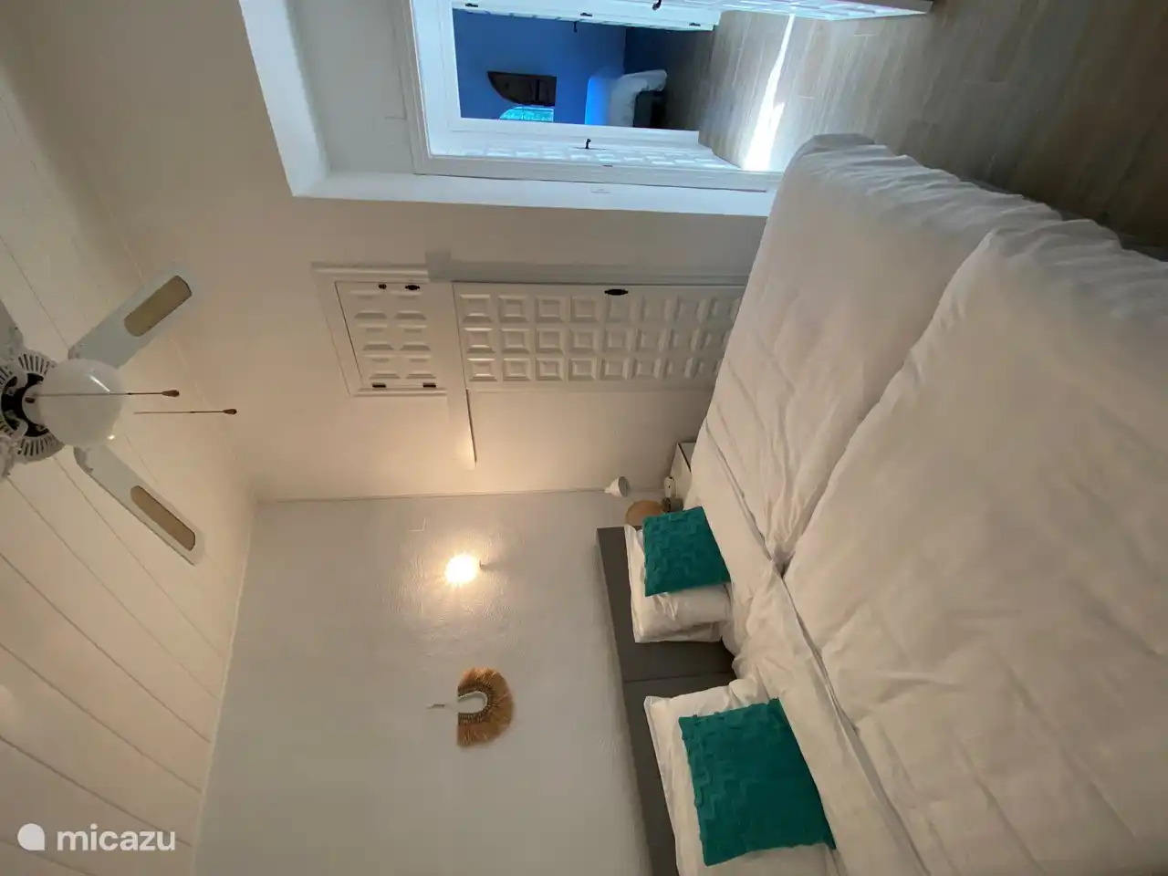 This bedroom also has a built-in wardrobe with shelves and a rod with many clothes hangers. And in this cupboard is the ironing board and iron.