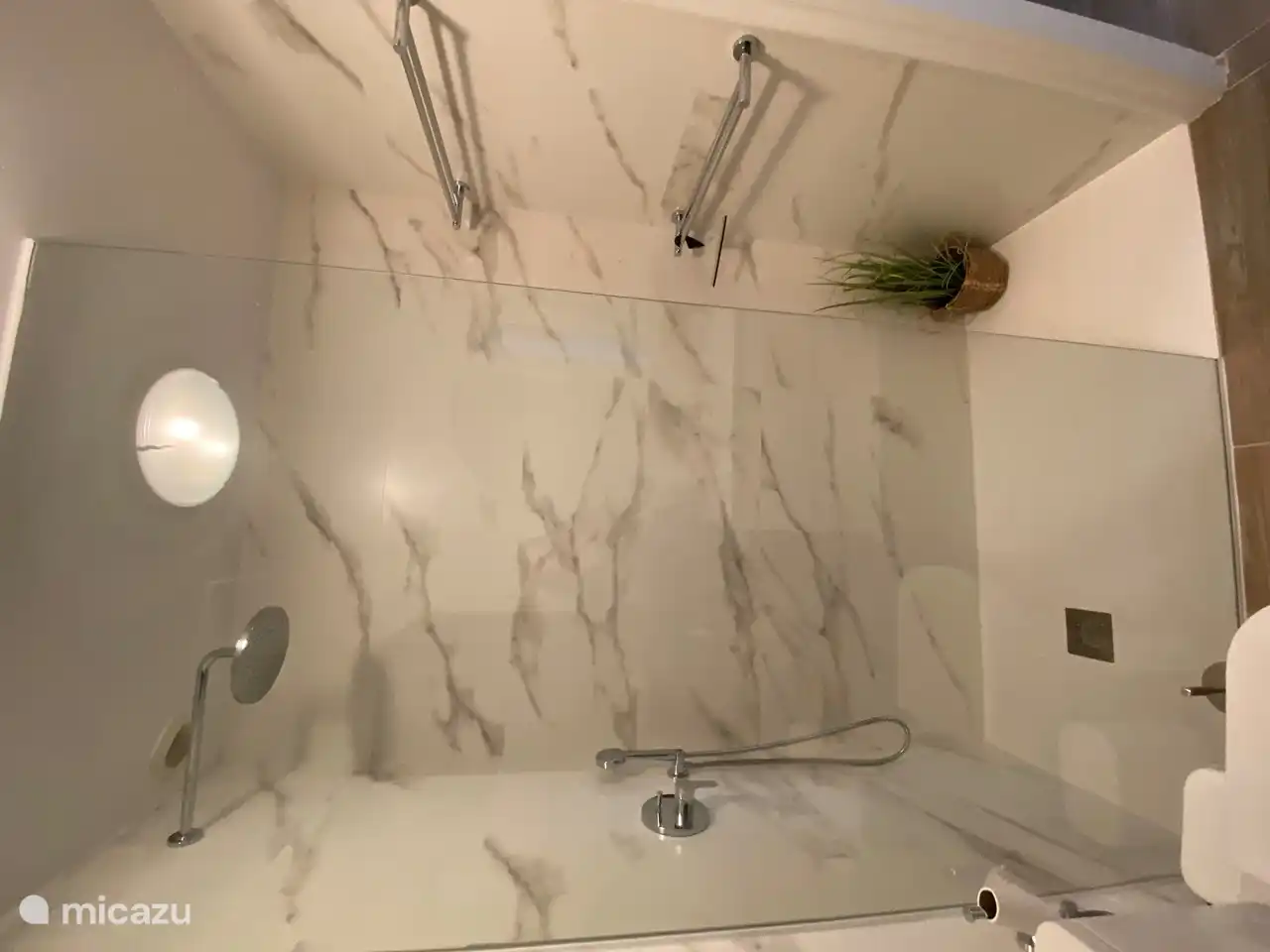 The spacious luxury walk-in shower with rain and hand shower. With towel rack.