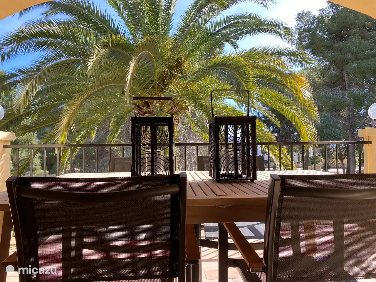 The dining table with chairs on the balcony.