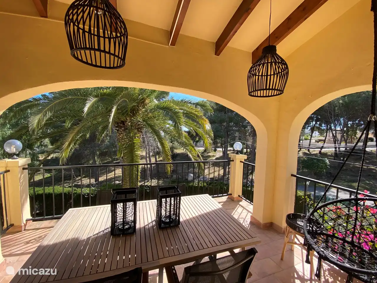 The balcony with the beautiful view of the palm tree, the garden and park.