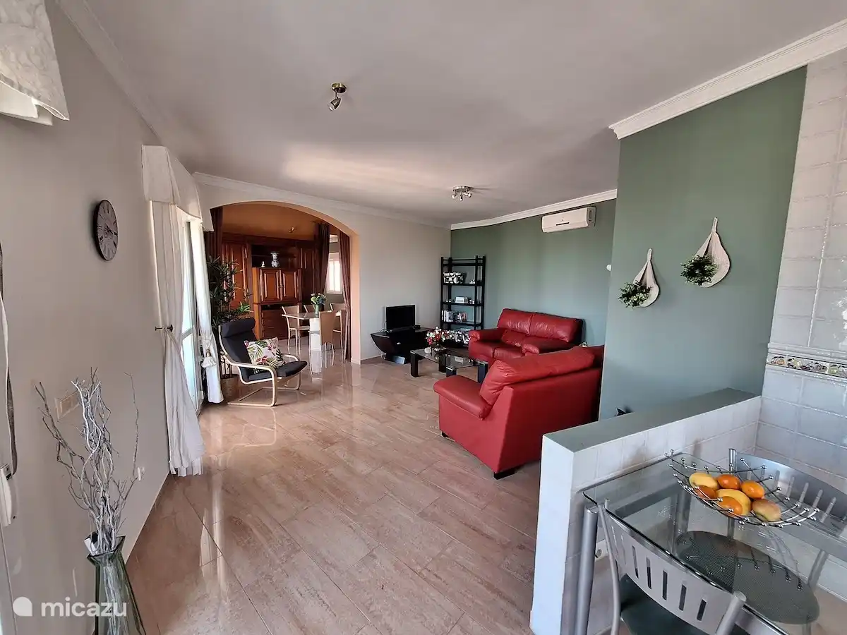 The Spanish furnished dining room with child-friendly furnishings of the living room with adjoining open kitchen.