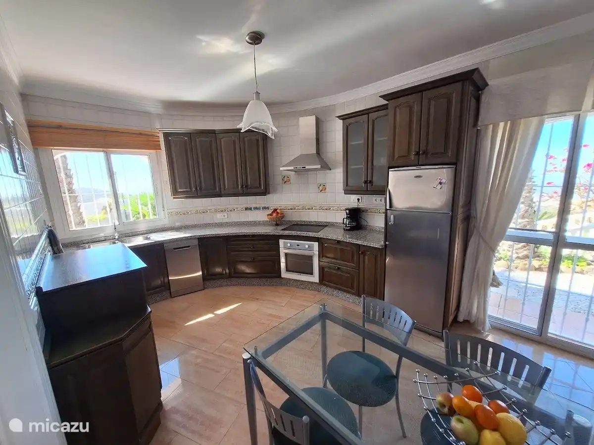 The practically equipped open kitchen with all modern conveniences, including a dishwasher. Missing equipment such as microwave and washing machine are in the adjacent machine room.