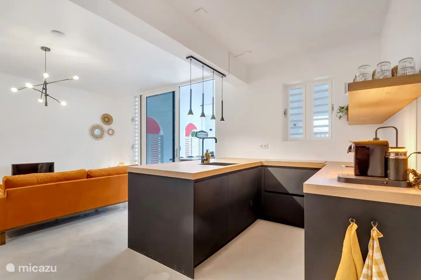 Open kitchen with dishwasher, combi oven, induction hob, American fridge and Nespresse coffee machine.