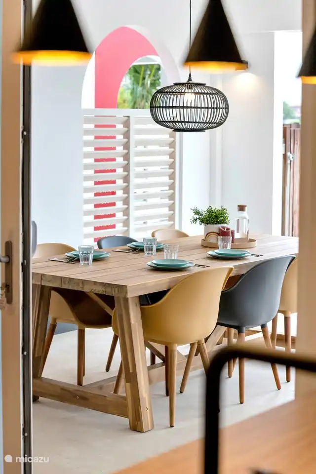 Covered porch with large dining table with 6 chairs.