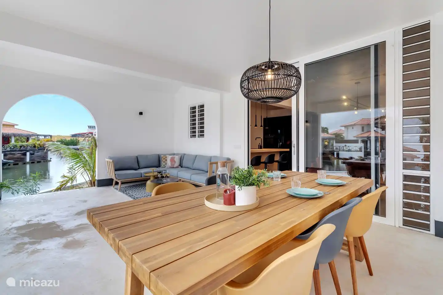 Covered porch with dining table with 6 chairs and lounge set.