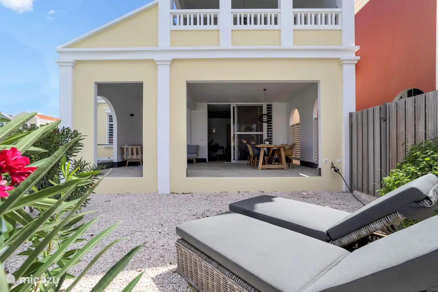 Garden with lounge beds, jacuzzi and access to the covered porch.