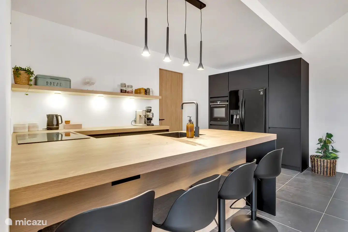 Offene Küche mit Geschirrspüler, Induktionskochfeld, amerikanischem Kühlschrank, Gefrierschrank, Espresso-Kaffeemaschine und Wasserkocher.