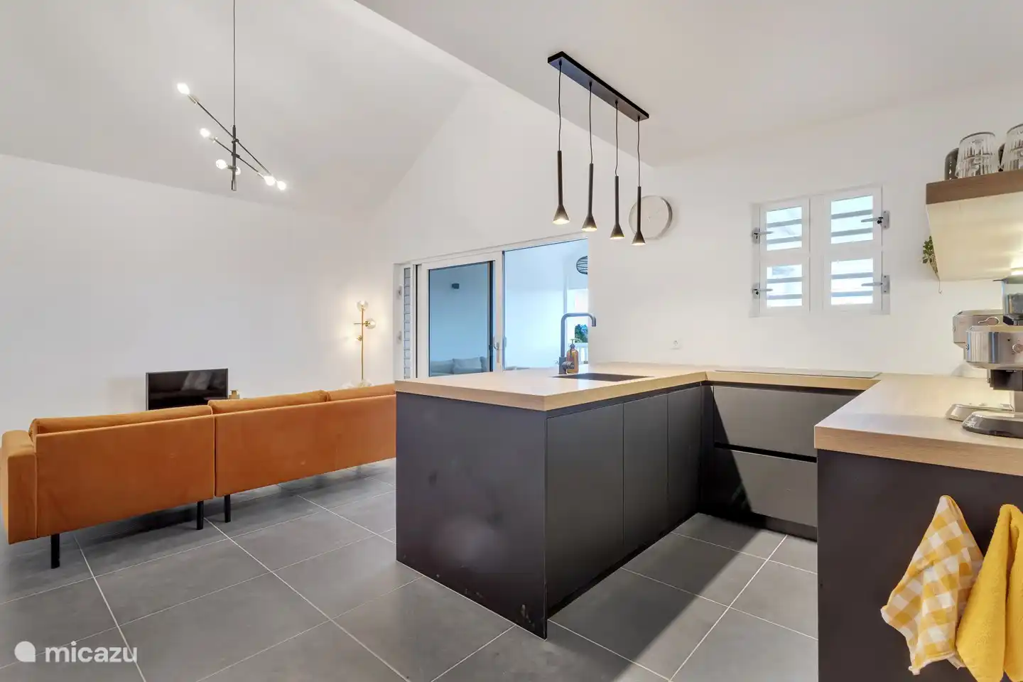 Offene Küche mit Geschirrspüler, Induktionskochfeld, amerikanischem Kühlschrank, Gefrierschrank, Espresso-Kaffeemaschine und Wasserkocher.